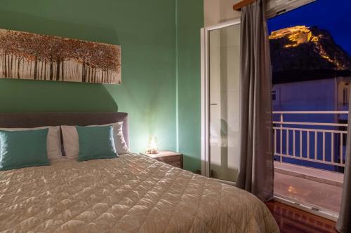 um quarto com uma cama e uma grande janela em Stork House family Nafplio em Nafplio
