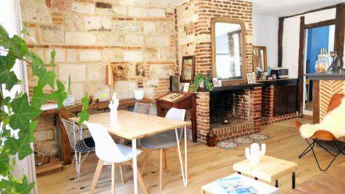 ein Esszimmer mit einem Tisch und einer Ziegelwand in der Unterkunft -Parking privé -La BATISSE -Coeur historique - La Clef de Honfleur in Honfleur