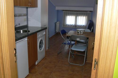 a kitchen with a sink and a washing machine at Casa Mariví in Niembro