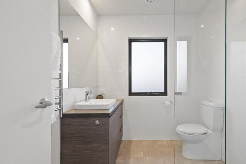 La salle de bains est pourvue de toilettes, d'un lavabo et d'une fenêtre. dans l'établissement TORQUAY Relax and Unwind Beach 300m Table Tennis, à Torquay