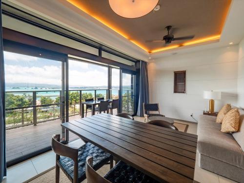 a living room with a wooden table and a large window at One Suite THE TERRACE in Nakijin