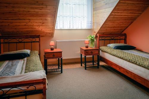 a bedroom with two beds and two tables with lamps at Pensjonat Cyrkon - strażnik młodszego Paleozoiku in Iwaniska