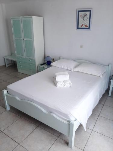 a bed in a bedroom with a green cabinet at Villa Nefeli in Perissa