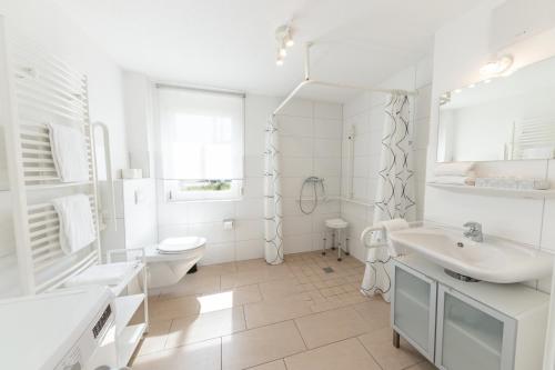biała łazienka z 2 umywalkami i toaletą w obiekcie Braviscasa - Ferienresidenz Haus am Bach Vogtsburg am Kaiserstuhl w mieście Vogtsburg im Kaiserstuhl
