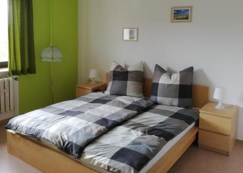 a bedroom with a bed with black and white pillows at Pension Zur alten Fachschule in Triptis