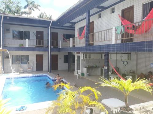 a man in a swimming pool in front of a building at Pousada Sossego Salinas in Salinópolis