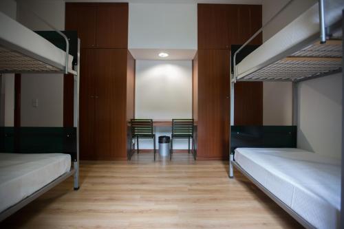 Zimmer mit Etagenbetten sowie einem Tisch und Stühlen in der Unterkunft HI Lousã – Pousada de Juventude in Lousã