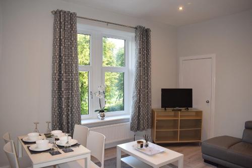 
a living room filled with furniture and a window at Kelpies Serviced Apartments- Victoria in Falkirk
