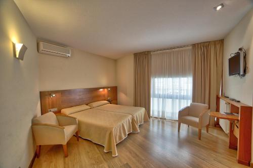 サンティアゴ・デ・コンポステーラにあるPR ロサ ロサエのベッドとテレビが備わるホテルルームです。