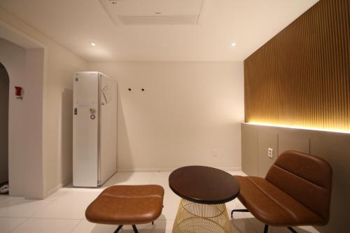 a kitchen with a table and chairs and a refrigerator at Biennale Hotel in Gwangju