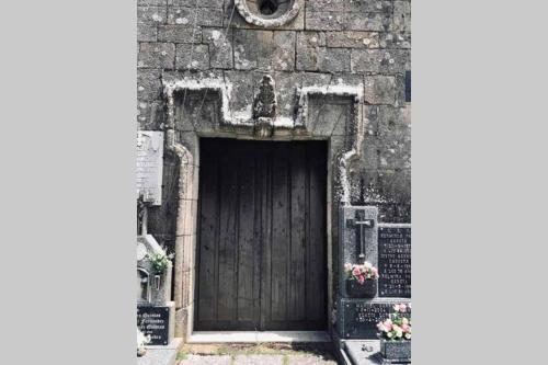 a wooden door in a stone building with flowers at CASA ALBA DE SAN ROMÁN in Ourense