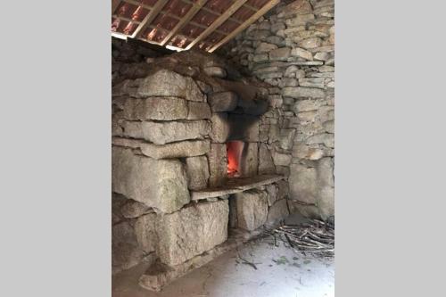 a stone oven with a fire in it at CASA ALBA DE SAN ROMÁN in Ourense