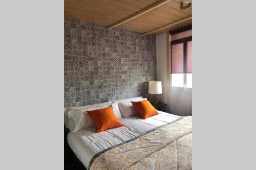 a bedroom with a bed with two orange pillows at CASA ALBA DE SAN ROMÁN in Ourense