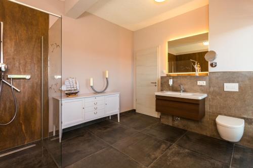 a bathroom with a sink and a toilet and a shower at Appartementhäuser Achterwasserblick in Ostseebad Koserow