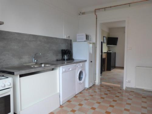 een keuken met een wastafel en een wasmachine bij gîte iaorana - maison en centre ville in Valognes