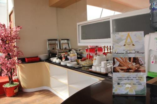 a restaurant with a counter with food on it at Antoni Hotel in Jakarta