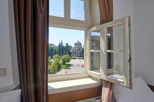 a room with a window with a view of a building at Hotel Splendid in Pleven