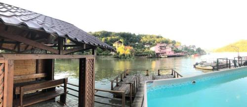 a swimming pool next to a river with a house at CARAVANAS in Orşova