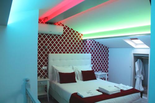 a bedroom with a white bed and white walls at ÍSIS Guest House in Braga