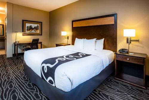 a hotel room with a large bed with white sheets at La Quinta by Wyndham Eugene in Eugene