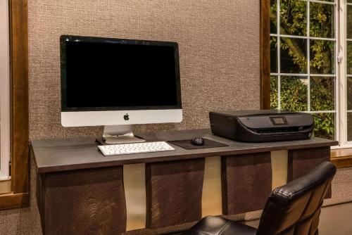 a desk with a computer monitor and a printer at La Quinta by Wyndham Eugene in Eugene