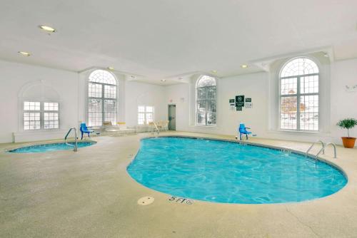 a large swimming pool with blue chairs in a room at La Quinta by Wyndham Cleveland Macedonia in Macedonia