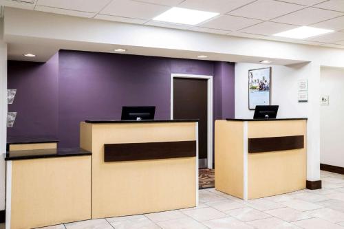 een lobby met paarse muren en 2 receptiebalies bij La Quinta Inn by Wyndham Davenport & Conference Center in Davenport