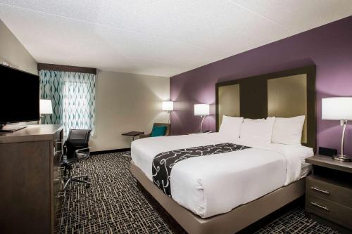 a hotel room with a large bed and a television at La Quinta Inn by Wyndham Davenport & Conference Center in Davenport