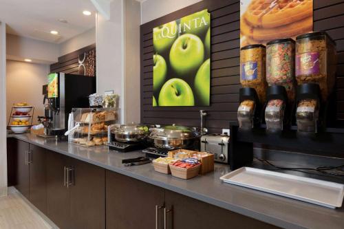 a coffee shop with a counter with food on it at La Quinta by Wyndham New York City Central Park in New York