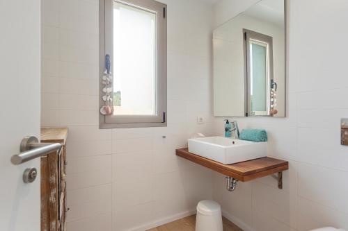 biała łazienka z umywalką i lustrem w obiekcie Sunny Townhouse With Terrace in Son Serra w mieście Son Serra de Marina