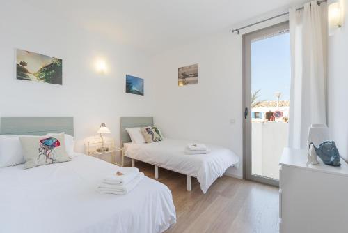 biały pokój z 2 łóżkami i oknem w obiekcie Sunny Townhouse With Terrace in Son Serra w mieście Son Serra de Marina