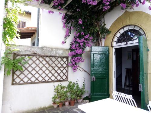 a house with a green door and purple flowers at L'OZioRinco Apartments in Florence