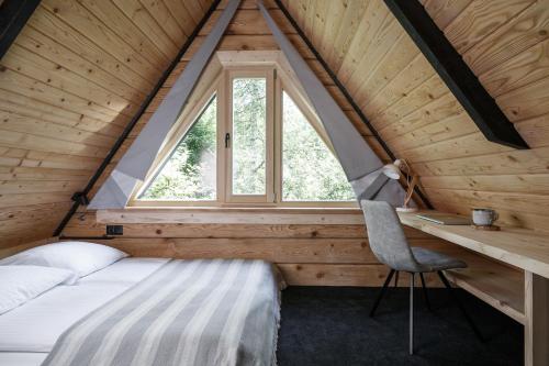 a bedroom with a bed and a desk and a window at Mount Apart Sport House in Zakopane