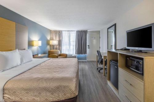 um quarto de hotel com uma cama e uma televisão de ecrã plano em Econo Lodge Middlesboro em Middlesboro