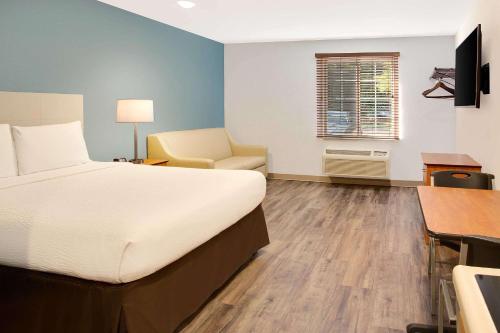 a bedroom with a bed and a desk and a chair at WoodSpring Suites Charlotte Shelby in Shelby