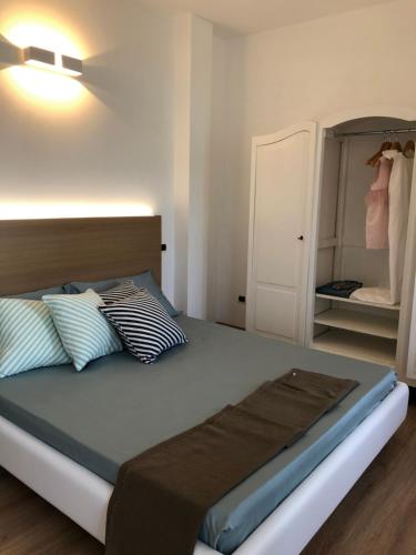a bedroom with a bed with pillows and a closet at Al Porticciolo - Casa Vacanze in Marone