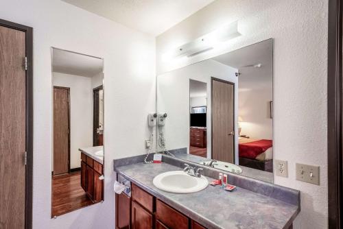 a bathroom with a sink and a large mirror at Econo Lodge in Canon City