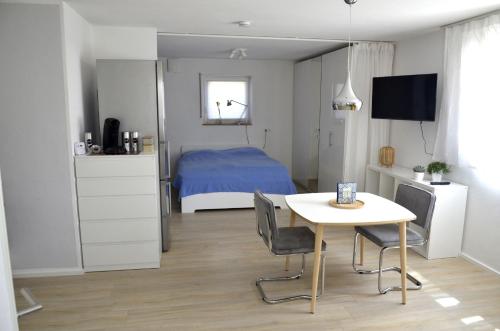 a bedroom with a bed and a table with chairs at Ferienwohnung Zaunkönig in Beuren