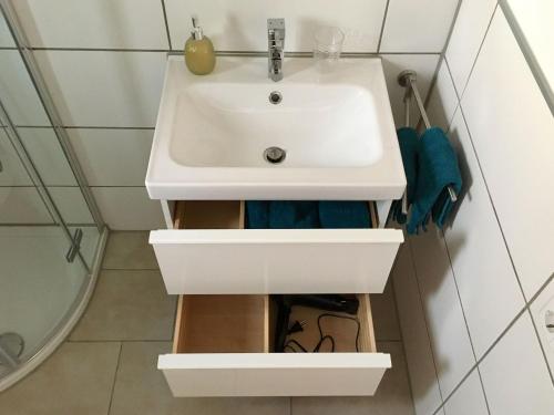 y baño con lavabo blanco y espejo. en Ferienwohnung Zaunkönig, en Beuren
