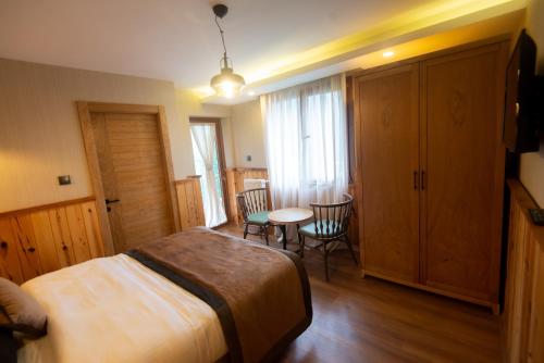 a bedroom with a bed and a table and chairs at Ayder Koru Hotel in Ayder Yaylasi