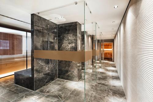 a walk in shower in a room with a glass wall at HYPERION Hotel Leipzig in Leipzig