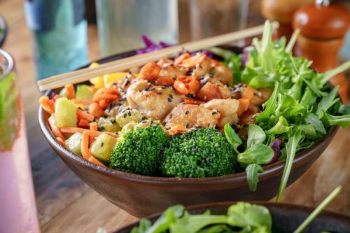 a bowl of food with shrimp and broccoli on a table at Hotel Indigo Berlin – Ku’damm by IHG in Berlin