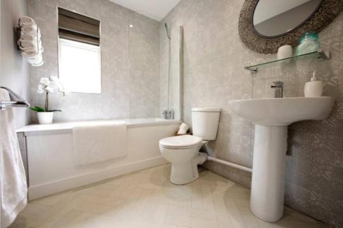W łazience znajduje się umywalka, toaleta i wanna. w obiekcie The Lodge w mieście Cowbridge