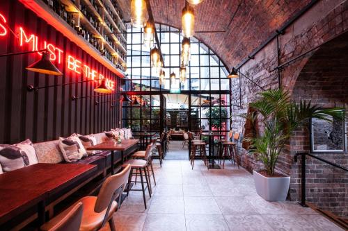 a restaurant with tables and chairs and a brick wall at The Address Connolly (formerly The North Star Hotel) in Dublin