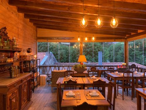 un restaurante con mesas y sillas de madera y ventanas en Storytellers Villas, en Sintra