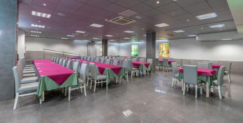 uma sala de jantar com mesas e cadeiras vermelhas e verdes em Manolo em Cartagena