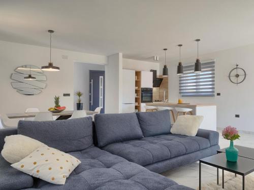 a living room with a blue couch and a kitchen at Villa Vine by Interhome in Marčana