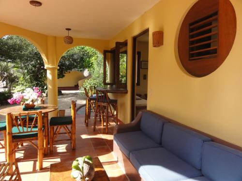 a living room with a couch and a table and chairs at Troncones Point Hostel in Troncones