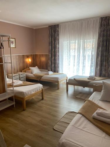 Habitación con 3 camas y ventana en City Westa Hotel, en Riga