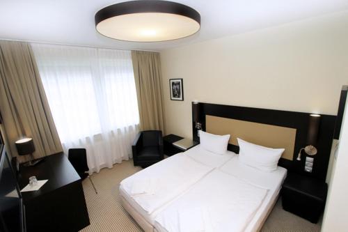 sypialnia z białym łóżkiem z czarnym zagłówkiem w obiekcie Karlstor Gästehaus w mieście Karlsruhe